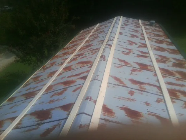 Rusted metal roof panels with new wood purlins before replacement — Storm Damage Roof Repair in Castalia by Roofing Brothers